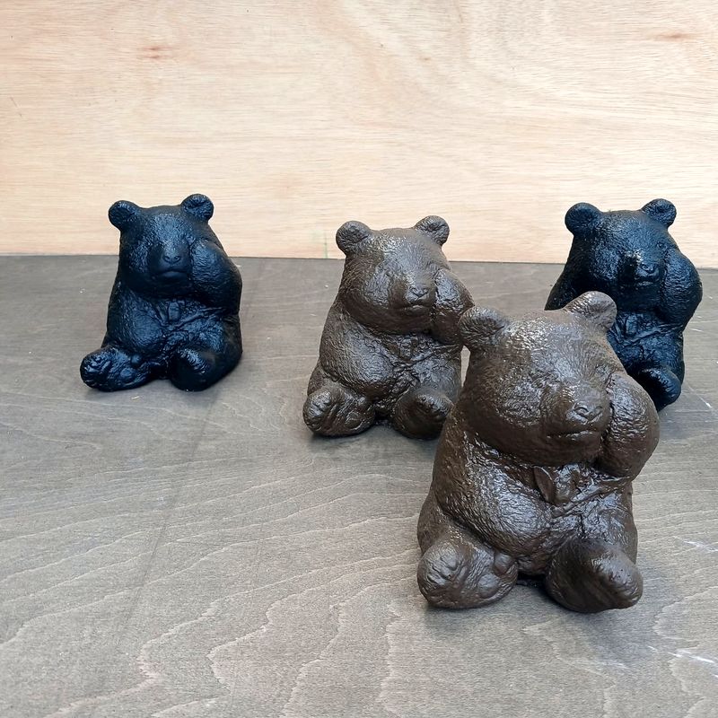 Four small bear statues in black and brown finishes