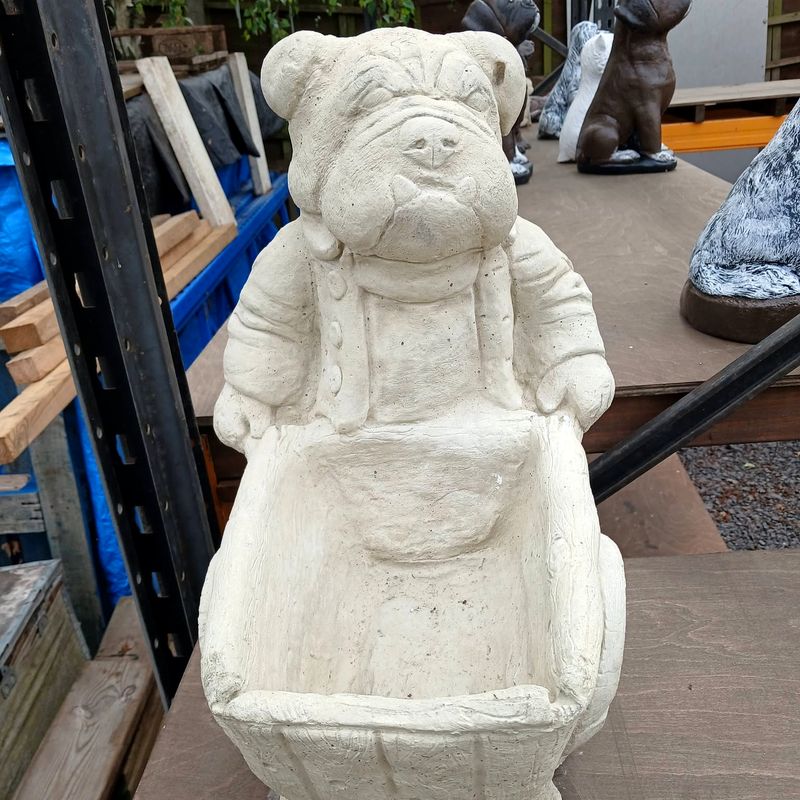 Bulldog in dungarees pushing a wheelbarrow planter, natural stone finish