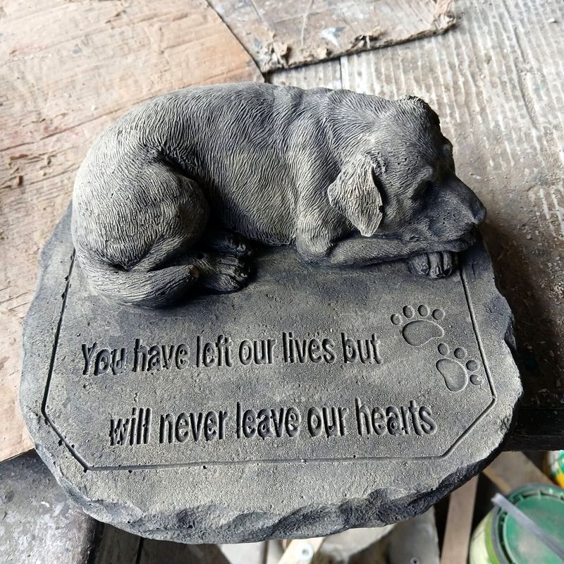 Memorial stone with a sleeping dog and the words: you have left our lives but will never leave our hearts